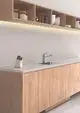 Moderne Küchenarmatur von Ideal Standard mit hohem Rohrauslauf und einem minimalistischen Design. Einfache Montage in einer eleganten Holz- und Steinumgebung.